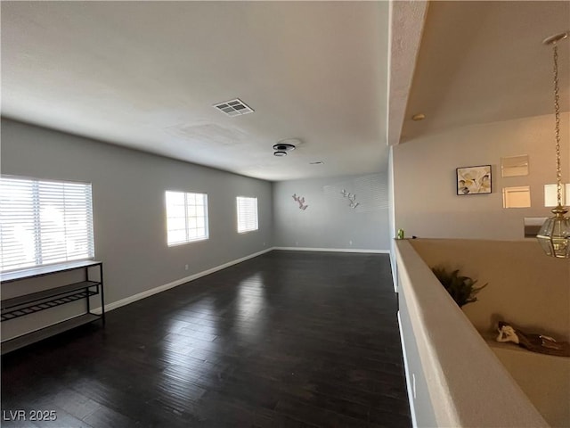 unfurnished room with dark wood-type flooring and baseboards