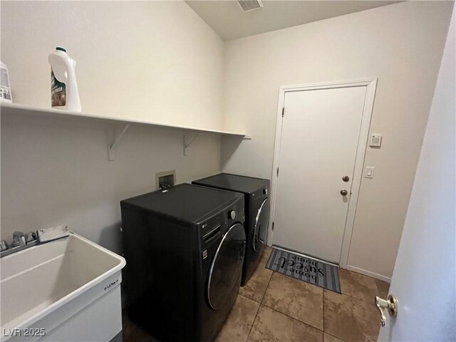 laundry area featuring washer and dryer and light tile patterned flooring