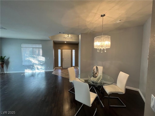 dining space with a chandelier and wood finished floors