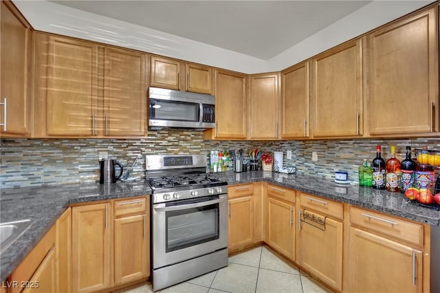 6430 Jackrabbit Run Ave, Las Vegas, NV 89122 - kitchen featuring stainless steel appliances, light tile patterned floors, tasteful backsplash, and dark stone counters