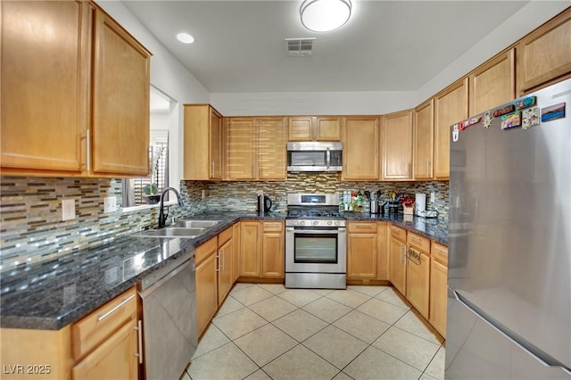 6430 Jackrabbit Run Ave, Las Vegas, NV 89122 - kitchen with stainless steel appliances, light tile patterned floors, backsplash, and dark stone countertops