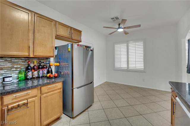 6430 Jackrabbit Run Ave, Las Vegas, NV 89122 - kitchen featuring freestanding refrigerator, backsplash, a ceiling fan, dark stone countertops, and light tile patterned floors