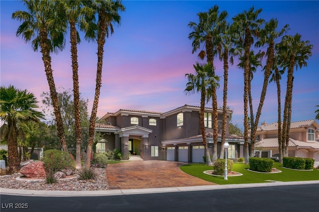 7520 Captains Harbor Dr, Las Vegas, NV 89117 - mediterranean / spanish-style home featuring a garage, a tiled roof, decorative driveway, and stucco siding