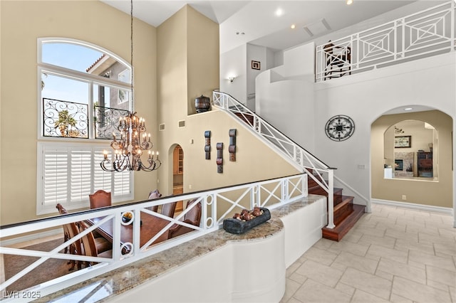 7520 Captains Harbor Dr, Las Vegas, NV 89117 - staircase with a towering ceiling, arched walkways, a chandelier, and stone finish flooring