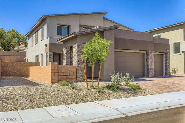 1289 Valencia Cliffs Ave, Henderson, NV 89012 - view of front facade featuring stucco siding, stone siding, driveway, and a garage