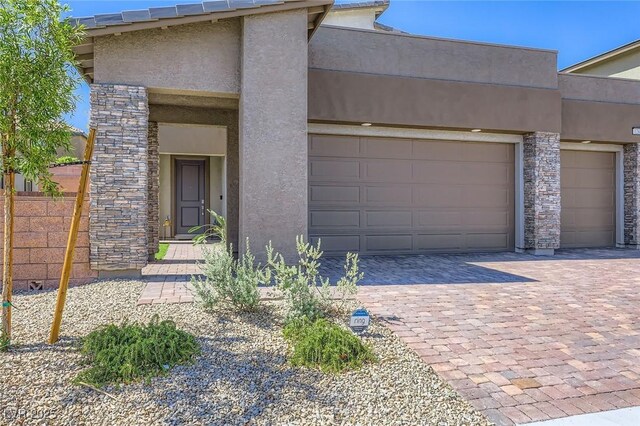 1289 Valencia Cliffs Ave, Henderson, NV 89012 - view of front of house with stucco siding, decorative driveway, and stone siding