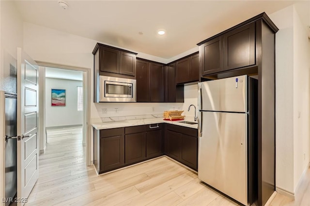 1289 Valencia Cliffs Ave, Henderson, NV 89012 - kitchen with appliances with stainless steel finishes, dark brown cabinets, light wood-type flooring, and recessed lighting