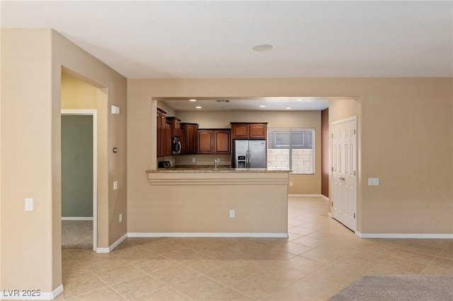 4117 Gliding Gulls Ave, North Las Vegas, NV 89084 - kitchen featuring appliances with stainless steel finishes, light tile patterned floors, a peninsula, light stone countertops, and recessed lighting
