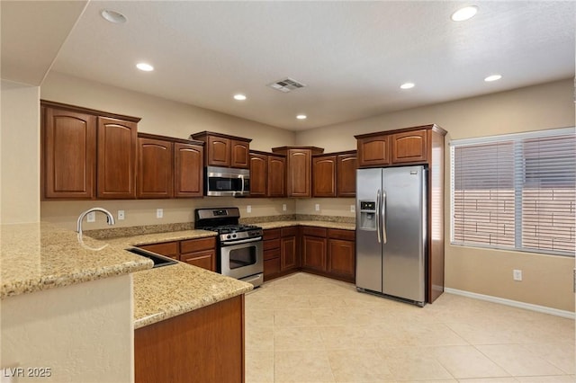 4117 Gliding Gulls Ave, North Las Vegas, NV 89084 - kitchen with stainless steel appliances, light stone counters, recessed lighting, light tile patterned flooring, and a peninsula