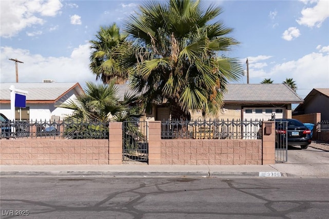 3308 Tabor Ave, North Las Vegas, NV 89030 - view of property hidden behind natural elements featuring a fenced front yard, a garage, driveway, and stucco siding
