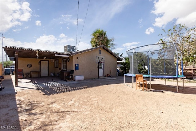 3308 Tabor Ave, North Las Vegas, NV 89030 - back of house featuring a trampoline and stucco siding