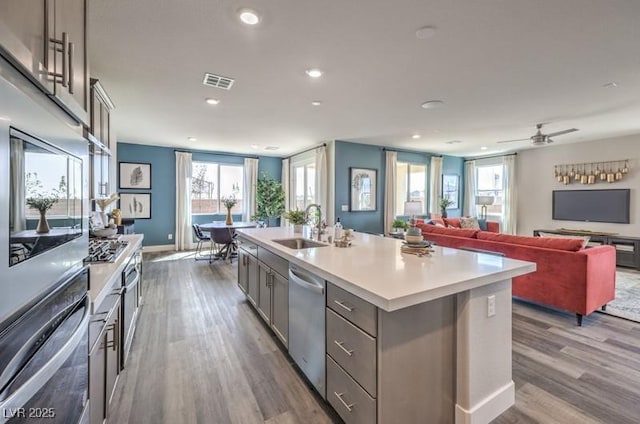 1408 Eva Creek Dr Unit 27, North Las Vegas, NV 89084 - kitchen with stainless steel appliances, gray cabinets, wood finished floors, light countertops, and recessed lighting