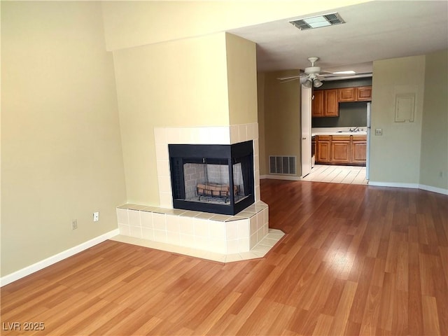 1940 Las Palmas Ln Unit 272, Laughlin, NV 89029 - unfurnished living room featuring light wood finished floors, a fireplace, and ceiling fan