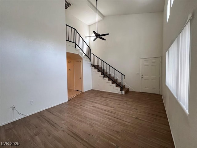 5253 Westwind Rd, Las Vegas, NV 89118 - unfurnished living room featuring high vaulted ceiling, stairs, a ceiling fan, and wood finished floors