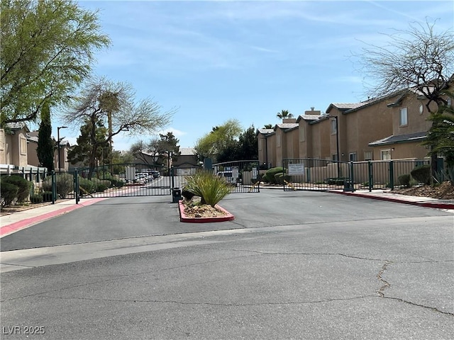 5253 Westwind Rd, Las Vegas, NV 89118 - view of asphalt street featuring sidewalks, a residential view, a gated entry, and curbs