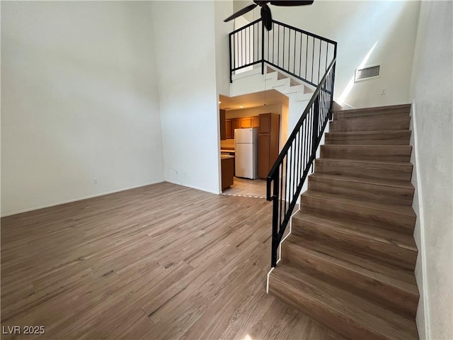 5253 Westwind Rd, Las Vegas, NV 89118 - stairway featuring ceiling fan, a towering ceiling, and wood finished floors