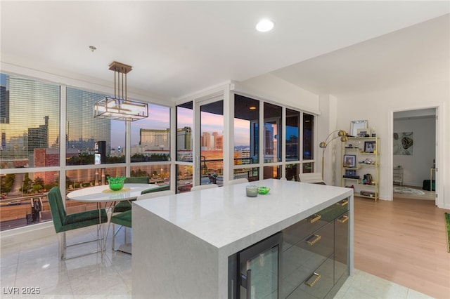 4525 Dean Martin Dr Unit 1007, Las Vegas, NV 89103 - kitchen with beverage cooler, pendant lighting, a center island, light countertops, and light wood-style floors