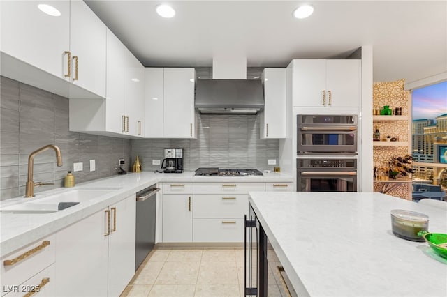 4525 Dean Martin Dr Unit 1007, Las Vegas, NV 89103 - kitchen with appliances with stainless steel finishes, wall chimney range hood, light countertops, decorative backsplash, and white cabinetry