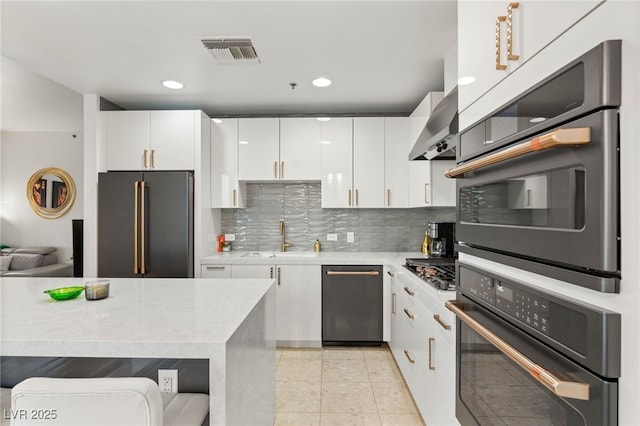 4525 Dean Martin Dr Unit 1007, Las Vegas, NV 89103 - kitchen featuring stainless steel appliances, light countertops, white cabinetry, decorative backsplash, and recessed lighting