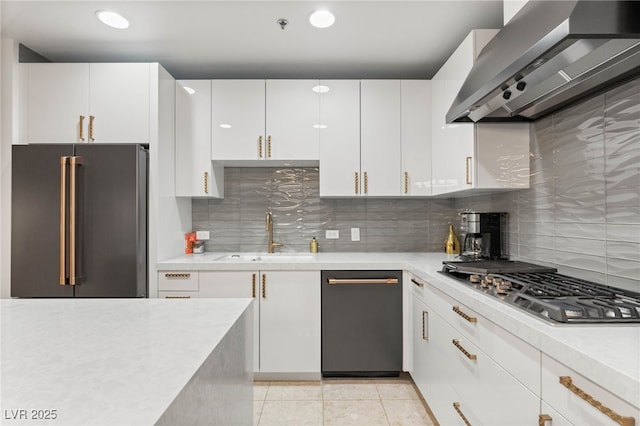 4525 Dean Martin Dr Unit 1007, Las Vegas, NV 89103 - kitchen featuring appliances with stainless steel finishes, wall chimney exhaust hood, light countertops, white cabinetry, and decorative backsplash