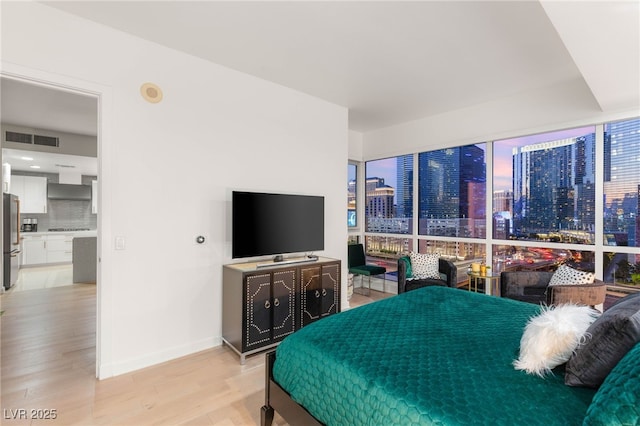 4525 Dean Martin Dr Unit 1007, Las Vegas, NV 89103 - bedroom with freestanding refrigerator and light wood-style flooring