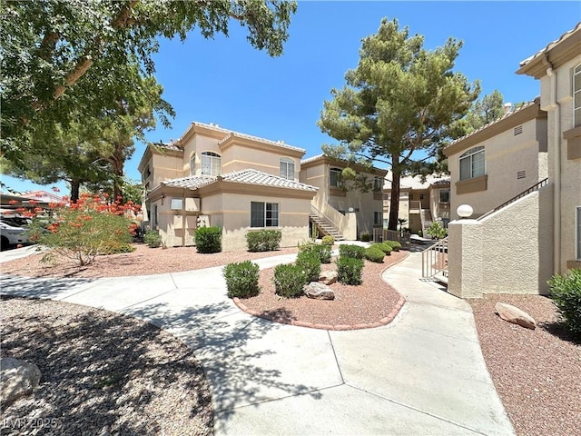 7400 W Flamingo Rd Unit 1094, Las Vegas, NV 89147 - view of front facade with stucco siding, a tile roof, and stairs