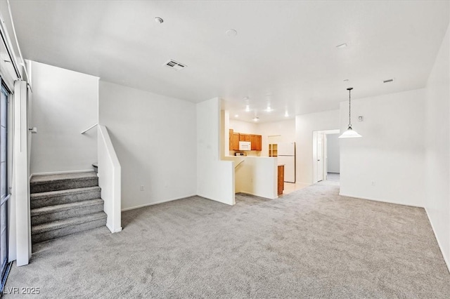 5960 Palmilla St Unit 7, North Las Vegas, NV 89031 - unfurnished living room with light colored carpet and stairway