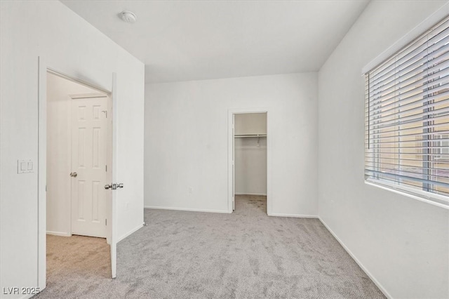 5960 Palmilla St Unit 7, North Las Vegas, NV 89031 - unfurnished bedroom featuring multiple windows, carpet floors, and a walk in closet