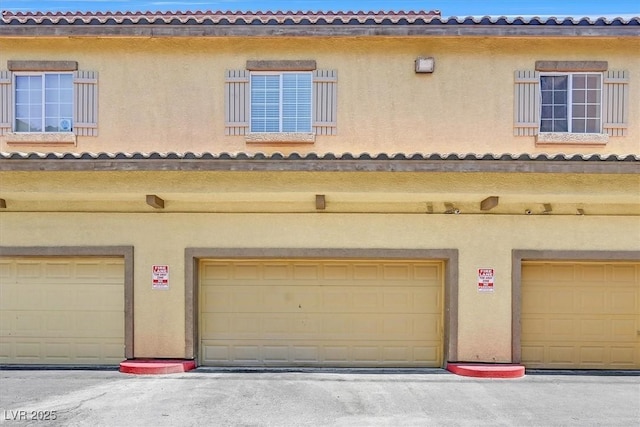 5960 Palmilla St Unit 7, North Las Vegas, NV 89031 - back of house with stucco siding and an attached garage