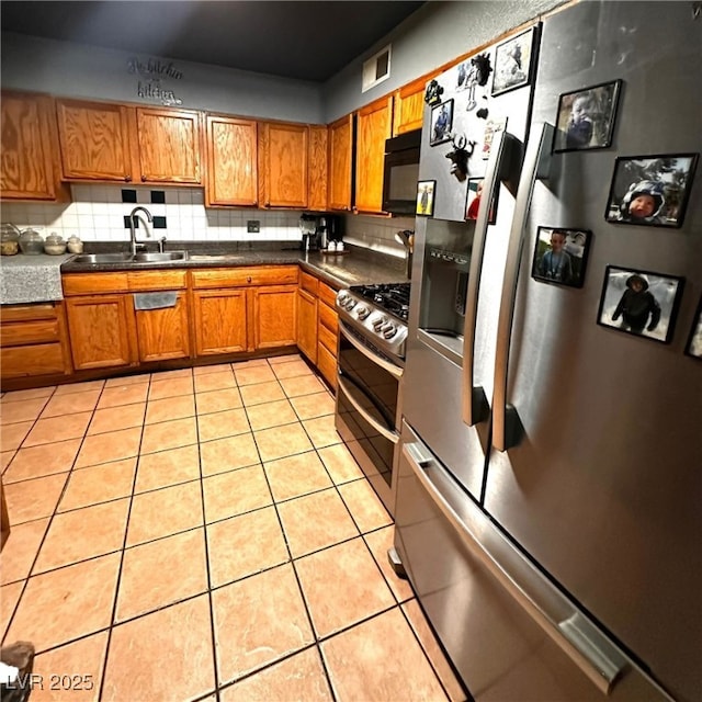 2709 Carroll St, North Las Vegas, NV 89030 - kitchen featuring stainless steel appliances, brown cabinetry, light tile patterned floors, and tasteful backsplash