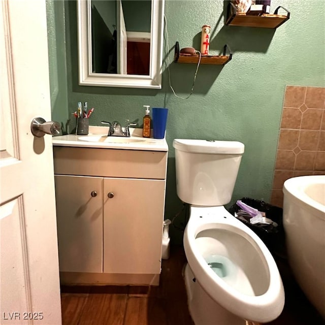2709 Carroll St, North Las Vegas, NV 89030 - bathroom featuring a textured wall, vanity, wood finished floors, and a bathtub