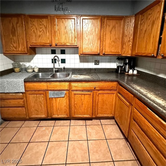2709 Carroll St, North Las Vegas, NV 89030 - kitchen with backsplash, brown cabinets, dark countertops, and light tile patterned floors
