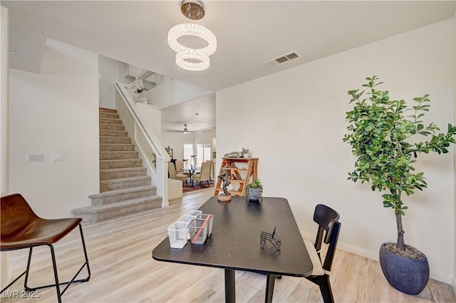10921 Calcedonian St, Las Vegas, NV 89141 - dining space featuring stairs, a chandelier, and light wood finished floors