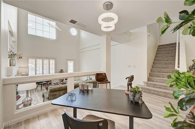 10921 Calcedonian St, Las Vegas, NV 89141 - dining space with wood finished floors, stairway, a chandelier, and a high ceiling