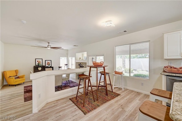 10921 Calcedonian St, Las Vegas, NV 89141 - kitchen with light wood-style flooring, white cabinetry, ceiling fan, dishwasher, and open floor plan