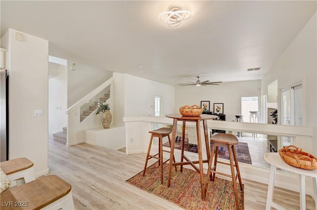 10921 Calcedonian St, Las Vegas, NV 89141 - dining room with light wood-style flooring, stairway, and a ceiling fan