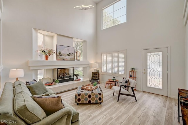 10921 Calcedonian St, Las Vegas, NV 89141 - living room featuring a high ceiling, wood finished floors, and a fireplace