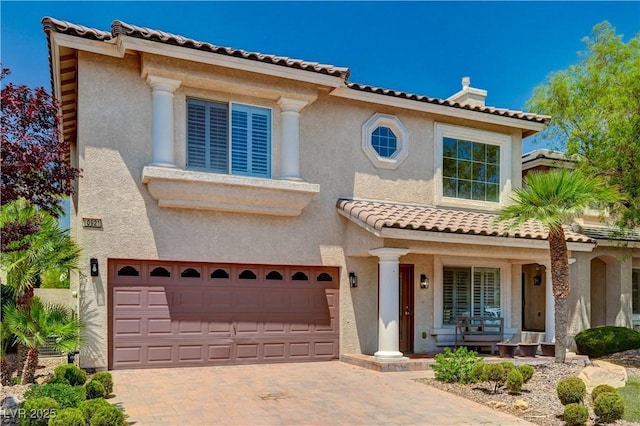 10921 Calcedonian St, Las Vegas, NV 89141 - mediterranean / spanish home with a porch, a garage, decorative driveway, and stucco siding