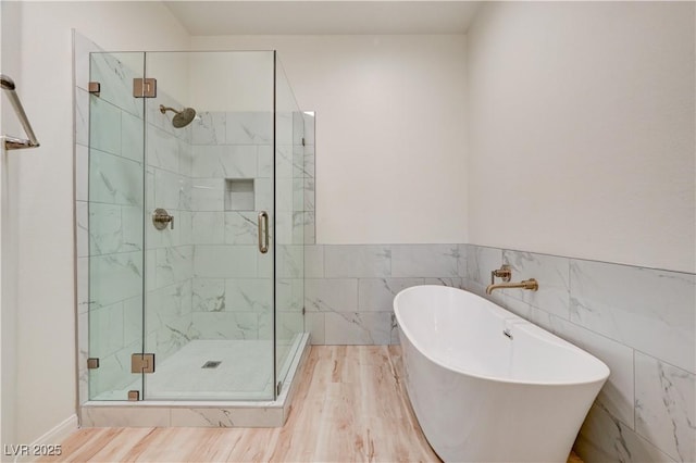 10921 Calcedonian St, Las Vegas, NV 89141 - full bath featuring a freestanding bath, a stall shower, tile walls, wood finished floors, and a wainscoted wall