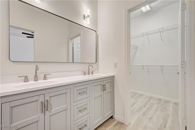 10921 Calcedonian St, Las Vegas, NV 89141 - bathroom featuring wood finished floors, double vanity, and a walk in closet