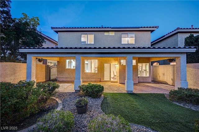10921 Calcedonian St, Las Vegas, NV 89141 - rear view of property featuring stucco siding, a lawn, and a patio area