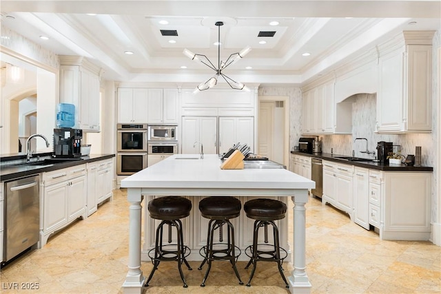 30 Augusta Canyon Way, Las Vegas, NV 89141 - kitchen featuring stainless steel appliances, a center island with sink, a kitchen bar, crown molding, and a raised ceiling