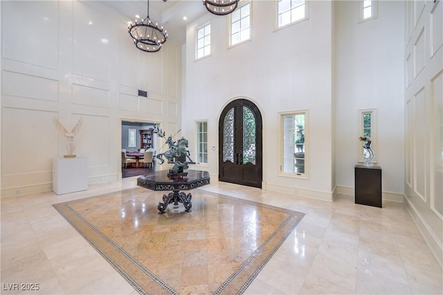30 Augusta Canyon Way, Las Vegas, NV 89141 - entrance foyer featuring a high ceiling, french doors, a chandelier, inlaid floor details, and light marble finish flooring
