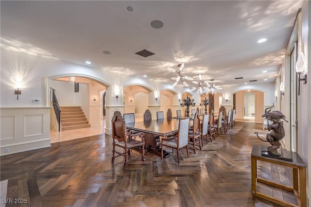 30 Augusta Canyon Way, Las Vegas, NV 89141 - dining room with arched walkways, stairway, a wainscoted wall, recessed lighting, and a chandelier