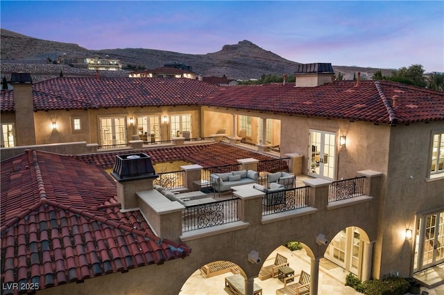30 Augusta Canyon Way, Las Vegas, NV 89141 - back of house at dusk featuring french doors, a chimney, a tiled roof, and an outdoor living space