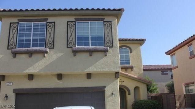 3711 Lodina Ct, Las Vegas, NV 89141 - view of side of property with an attached garage, stucco siding, and a tiled roof