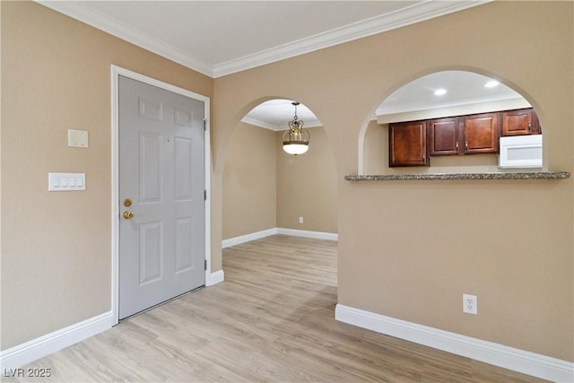 2451 N Rainbow Blvd Unit 1091, Las Vegas, NV 89108 - kitchen with white microwave, arched walkways, crown molding, and light wood-style floors