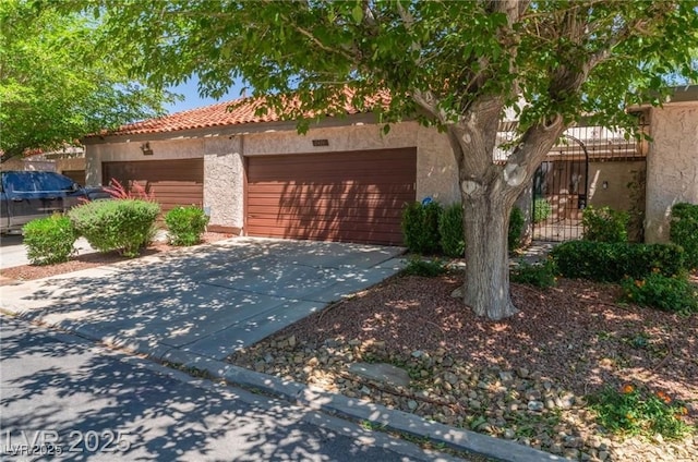 2486 Sabado St, Las Vegas, NV 89121 - view of front of house featuring concrete driveway, stucco siding, a tiled roof, and an attached garage