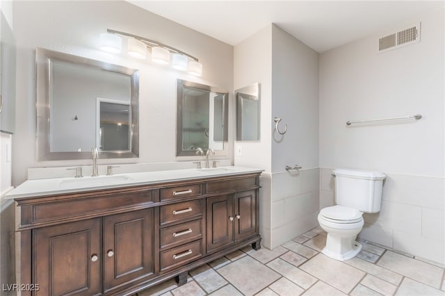 2486 Sabado St, Las Vegas, NV 89121 - bathroom with double vanity, tile walls, and a wainscoted wall