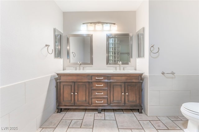 2486 Sabado St, Las Vegas, NV 89121 - bathroom with tile walls, double vanity, and wainscoting